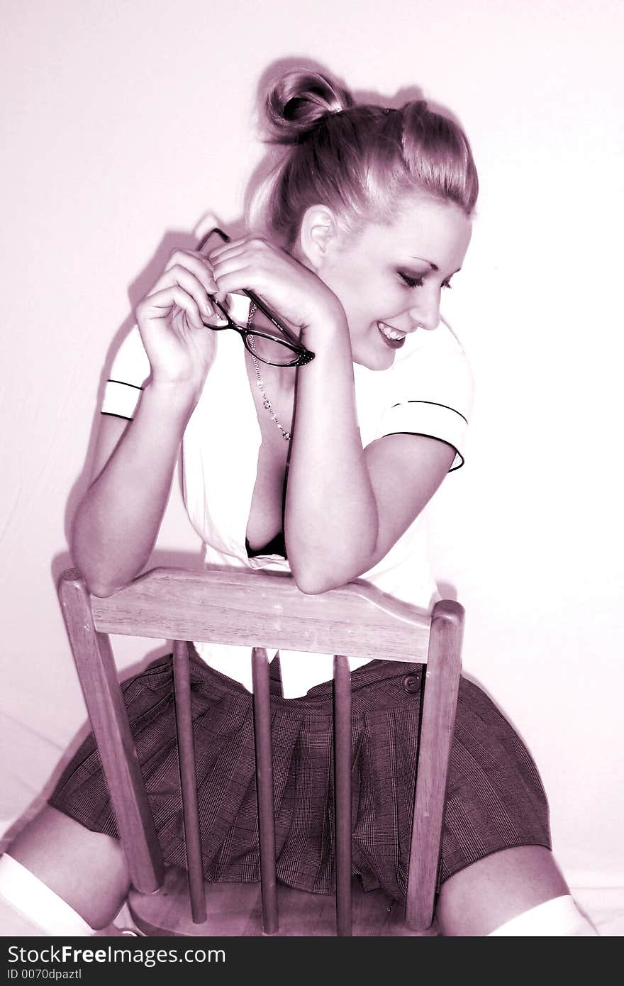 Model posing with skirt, glasses, on a chair. Model posing with skirt, glasses, on a chair.