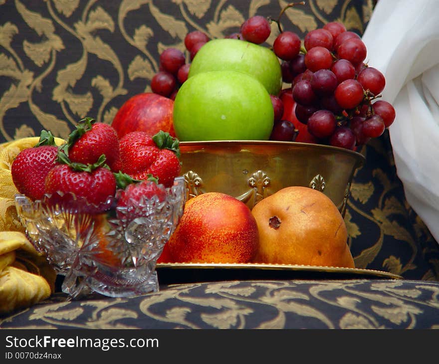 Bowl of fresh fruit on white table cloth with dark background. Bowl of fresh fruit on white table cloth with dark background