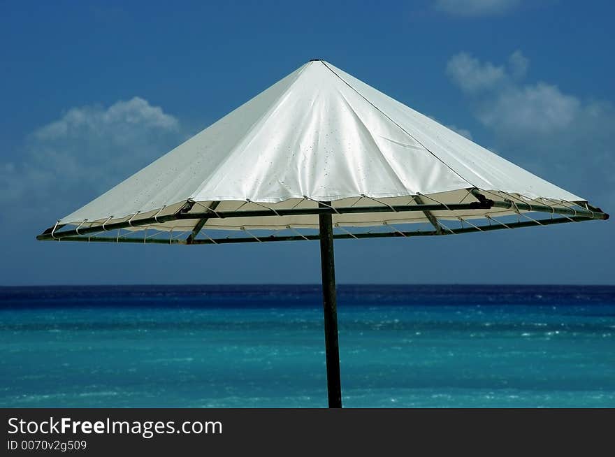 A parasol on a deserted beach. A parasol on a deserted beach