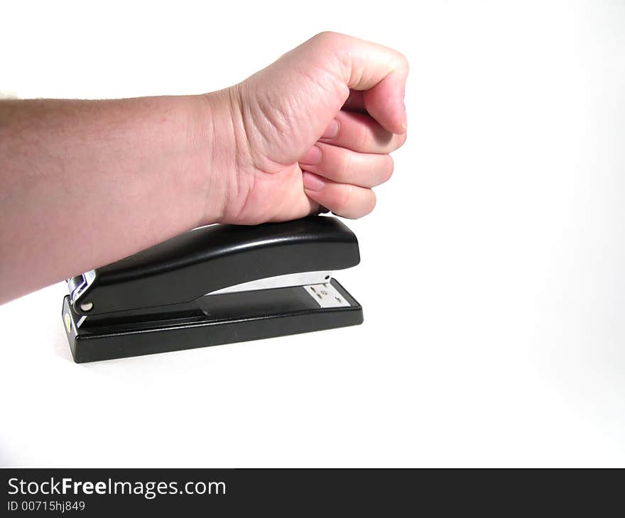 Large hand pounding a stapler in frustration. Large hand pounding a stapler in frustration