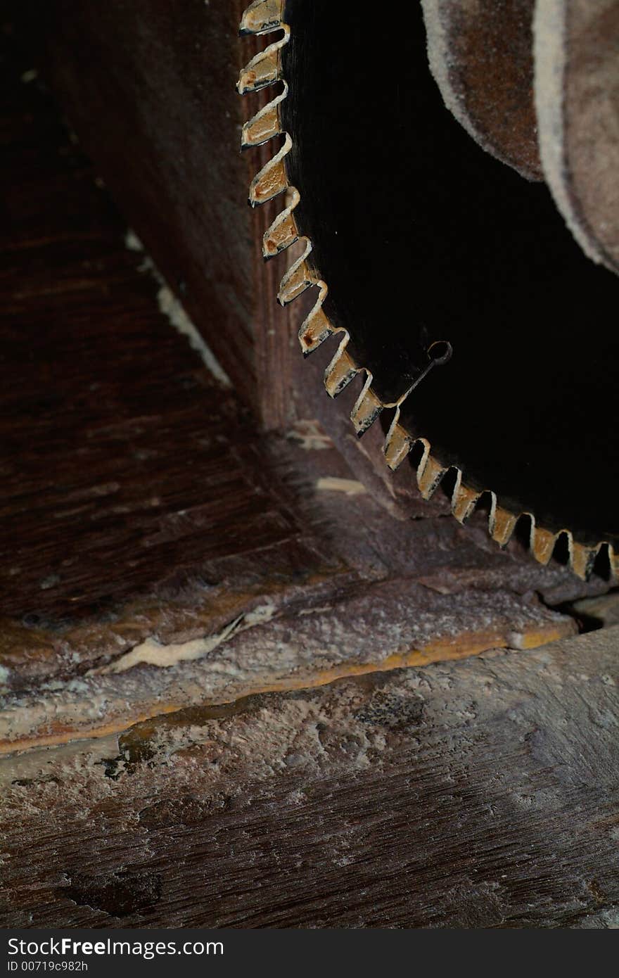 Part of circular saw on an old wooden work-bench. Part of circular saw on an old wooden work-bench