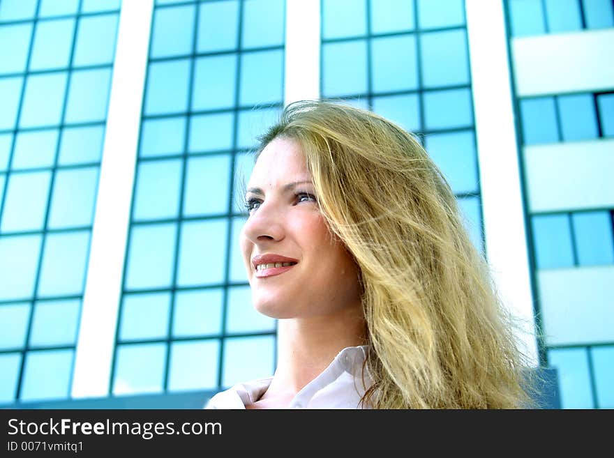 Bussines woman in front of blueish corporate building. Bussines woman in front of blueish corporate building