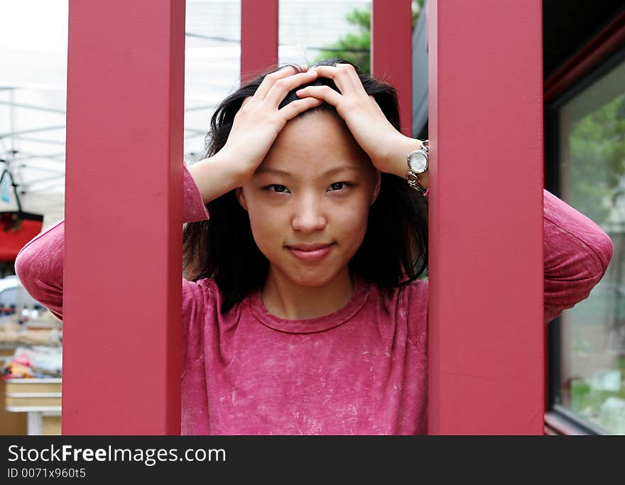 Pretty Korean woman looking through bars. Pretty Korean woman looking through bars