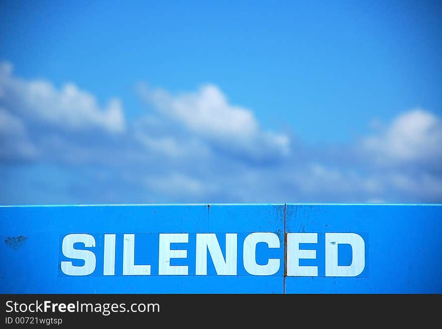 Silenced sign writen on top of machine and sky behind