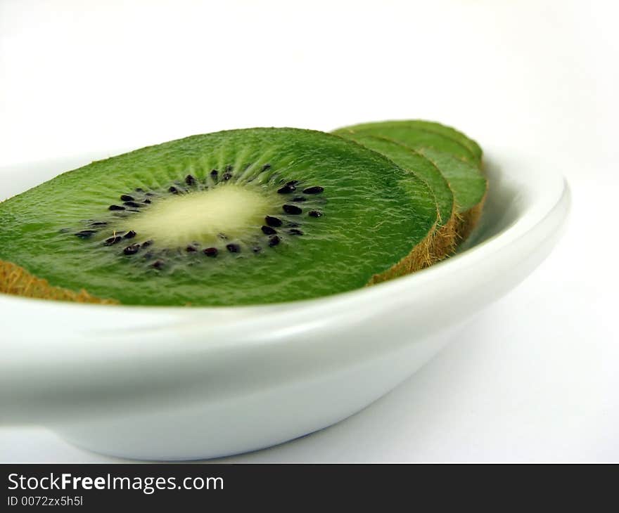 Kiwi slices on white plate, dof. Kiwi slices on white plate, dof