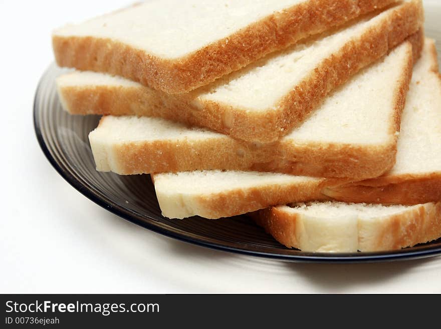 Slices of White bread on a plate against a white background