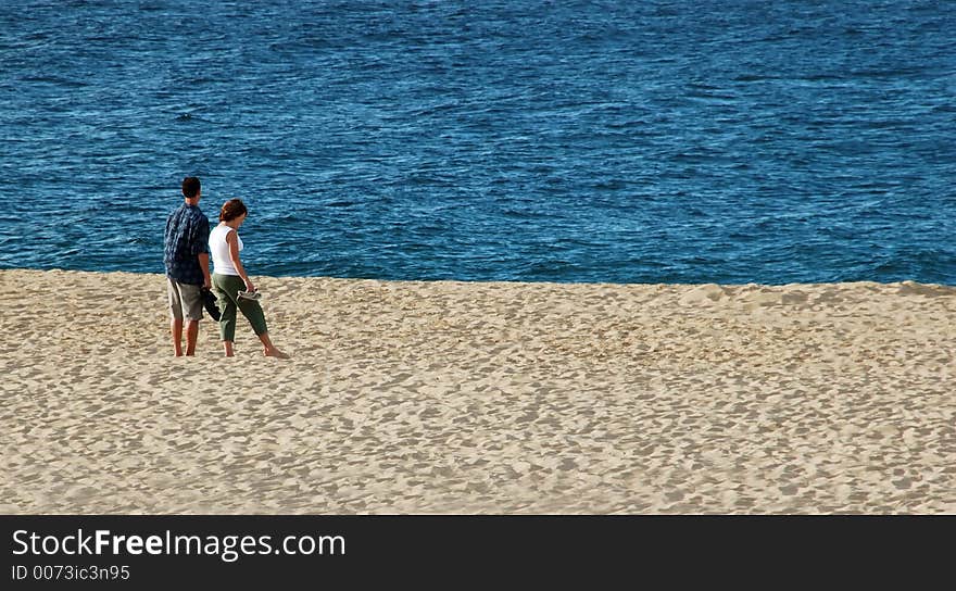 Couple Standing On Beach With Blue Blue Ocean