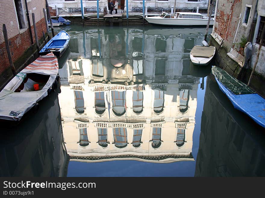 A building reflected in the still water of a Venice canal. A building reflected in the still water of a Venice canal