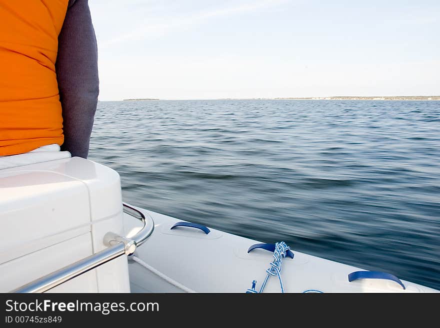 View from a rushing speedboat, coastline in the background. Slower shutter speed, motion blur on the water. View from a rushing speedboat, coastline in the background. Slower shutter speed, motion blur on the water.