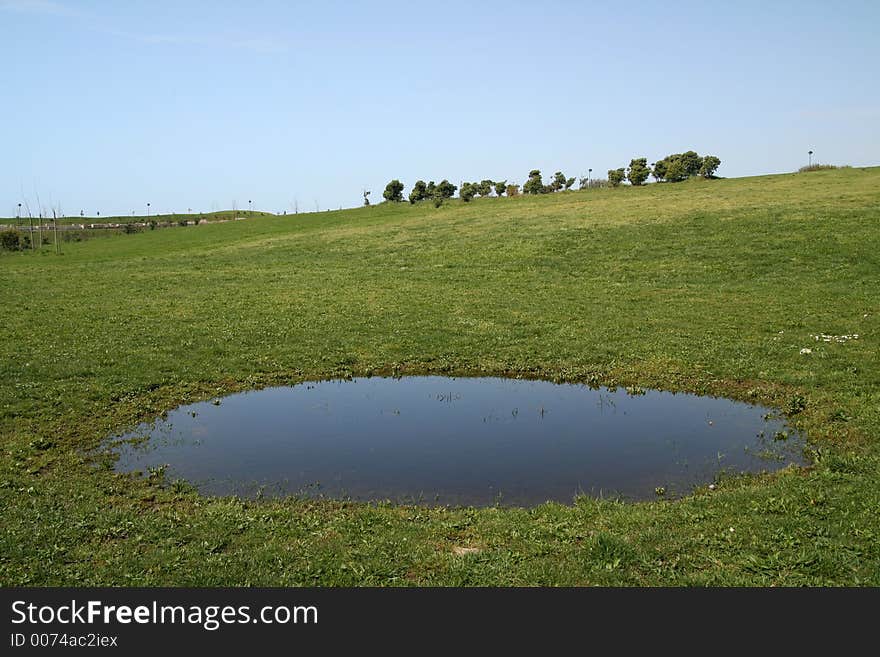 Green field - Landscape green grass, blue sky, white clouds and a lake