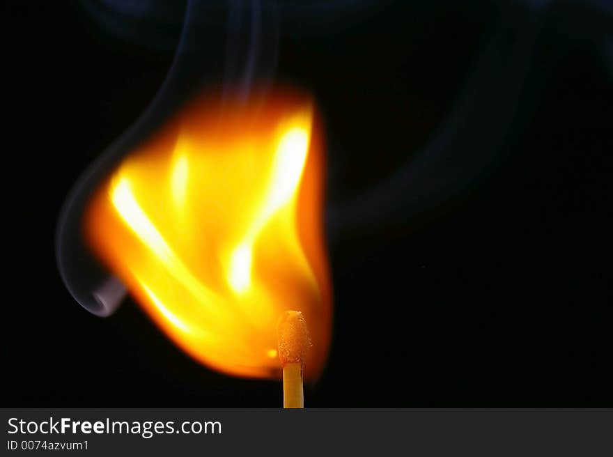 Closeup of a red-tipped wooden match stick at ignition.  Red, orange, yellow, and white flame.  Black background. Closeup of a red-tipped wooden match stick at ignition.  Red, orange, yellow, and white flame.  Black background.