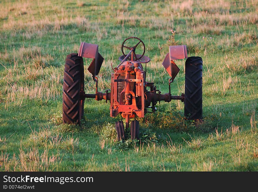 An antique tractor left to rust in a pasture in Iowa. An antique tractor left to rust in a pasture in Iowa.