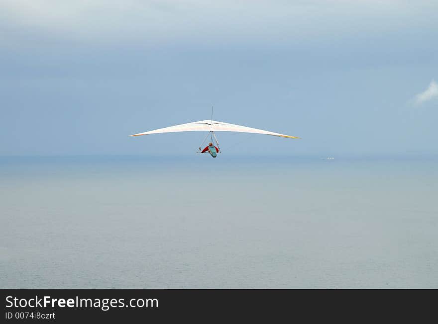 Man flying with a hang glider off the coast of Australia. Man flying with a hang glider off the coast of Australia