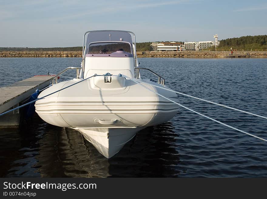 Modern lightweight speedboat docked safely in the harbour. Modern lightweight speedboat docked safely in the harbour.