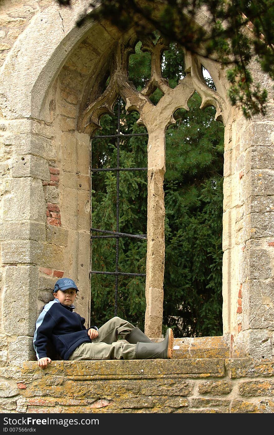 A boy relaxing in a window. A boy relaxing in a window