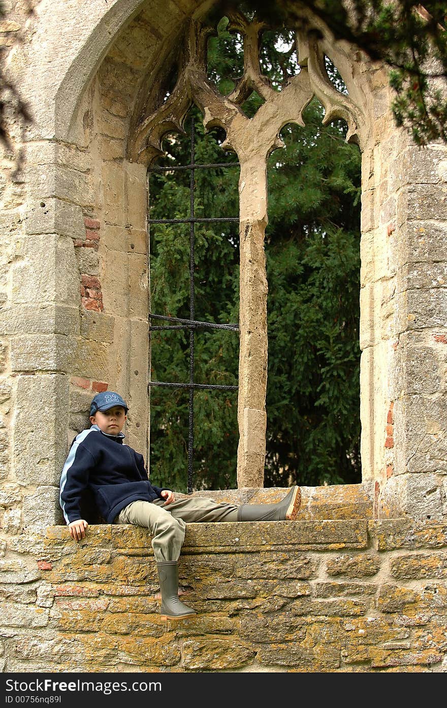 A boy relaxing in a window. A boy relaxing in a window