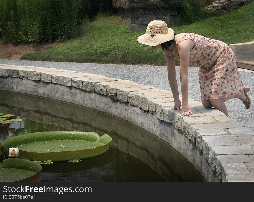 Woman in straw hat with flat lily pads. Woman in straw hat with flat lily pads