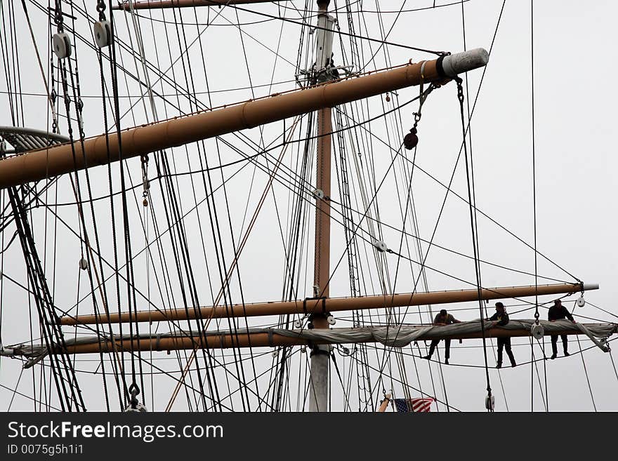 3 men working on mast. 3 men working on mast