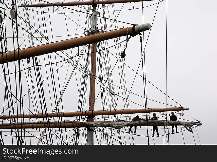 3 men working on mast. 3 men working on mast