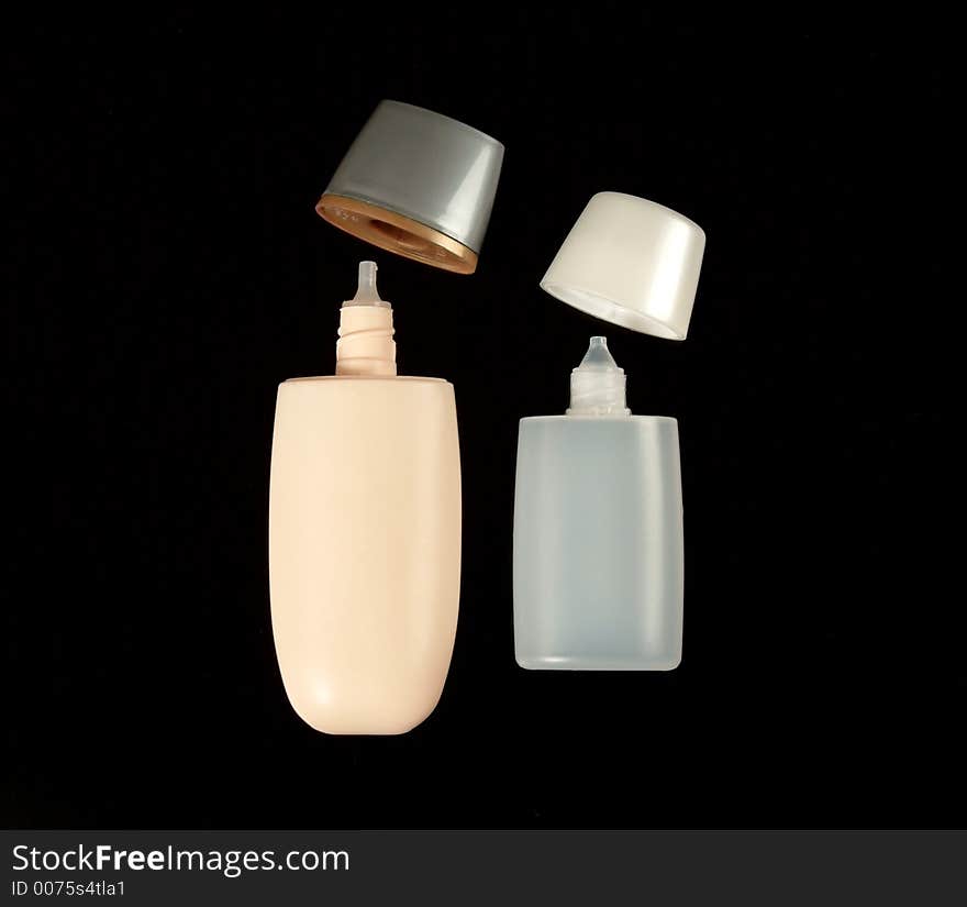 Empty small plastic bottles for cosmetics on solid black background