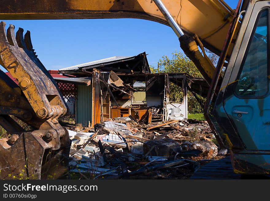 An excavator demolishes a burnt-out house. An excavator demolishes a burnt-out house.