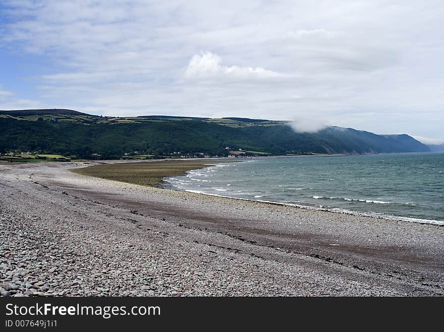 Sea coming in with a back drop of green hills