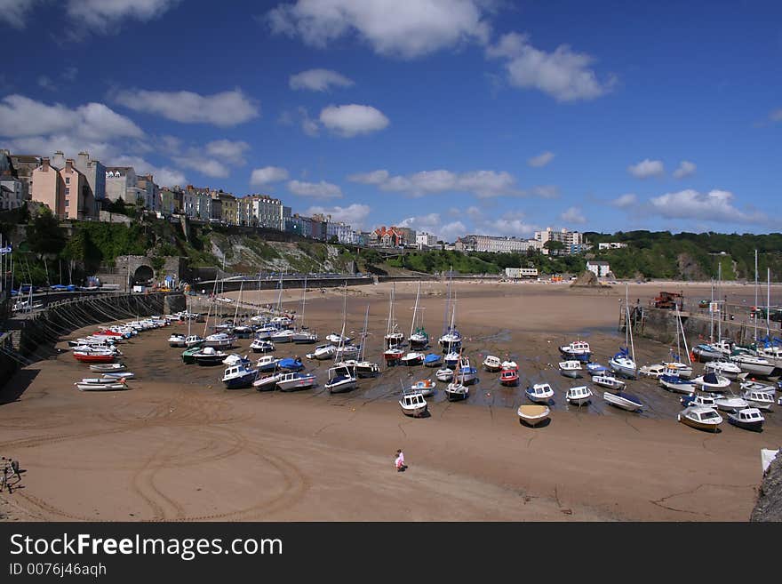Boats on the sand at low tide on Tenby beach, Wales, UK. Boats on the sand at low tide on Tenby beach, Wales, UK