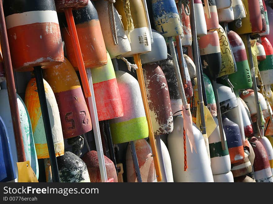 A colorful and eclectic wall of buoys seen at a New England dock.