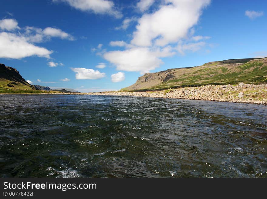 Wide angle shot of a scenic valley, shot in the middle of a river flowing in the valley. Wide angle shot of a scenic valley, shot in the middle of a river flowing in the valley