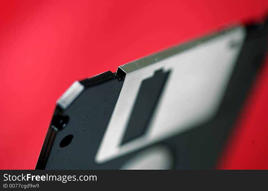 Old computer disk diskette on red background