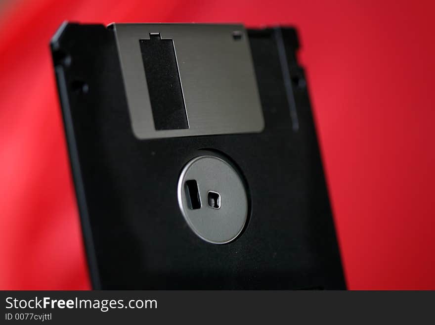 Old computer disk diskette on red background