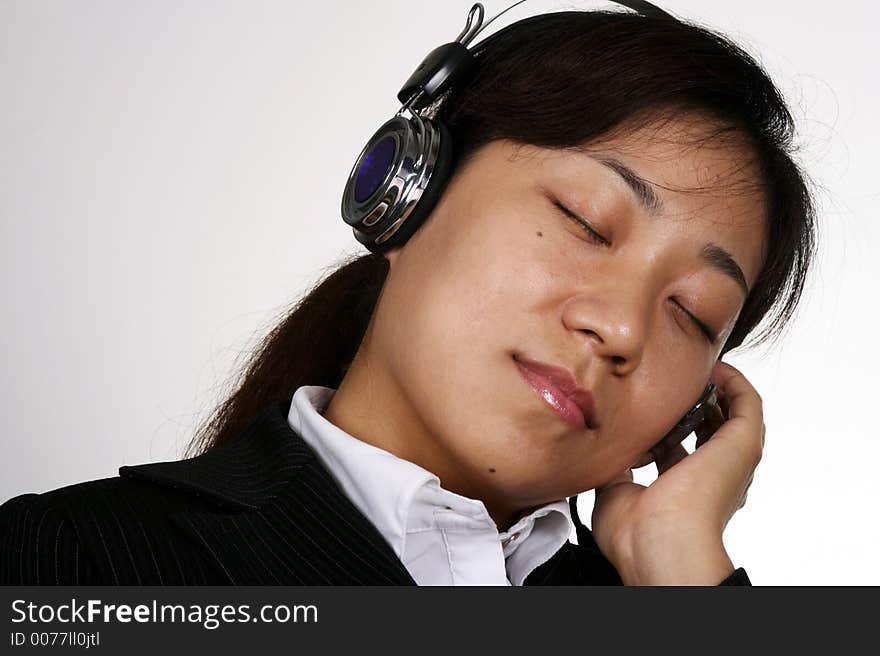 Asian businesswoman listening music in the office