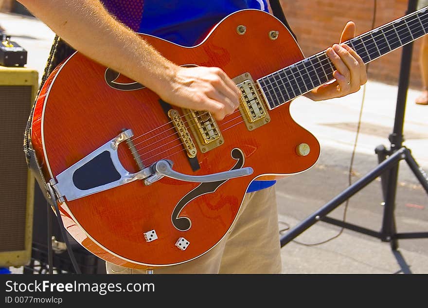 This beautiful red guitar was being played at a street concert.  It's unique details include two real dice rolled to a lucky seven. This beautiful red guitar was being played at a street concert.  It's unique details include two real dice rolled to a lucky seven.