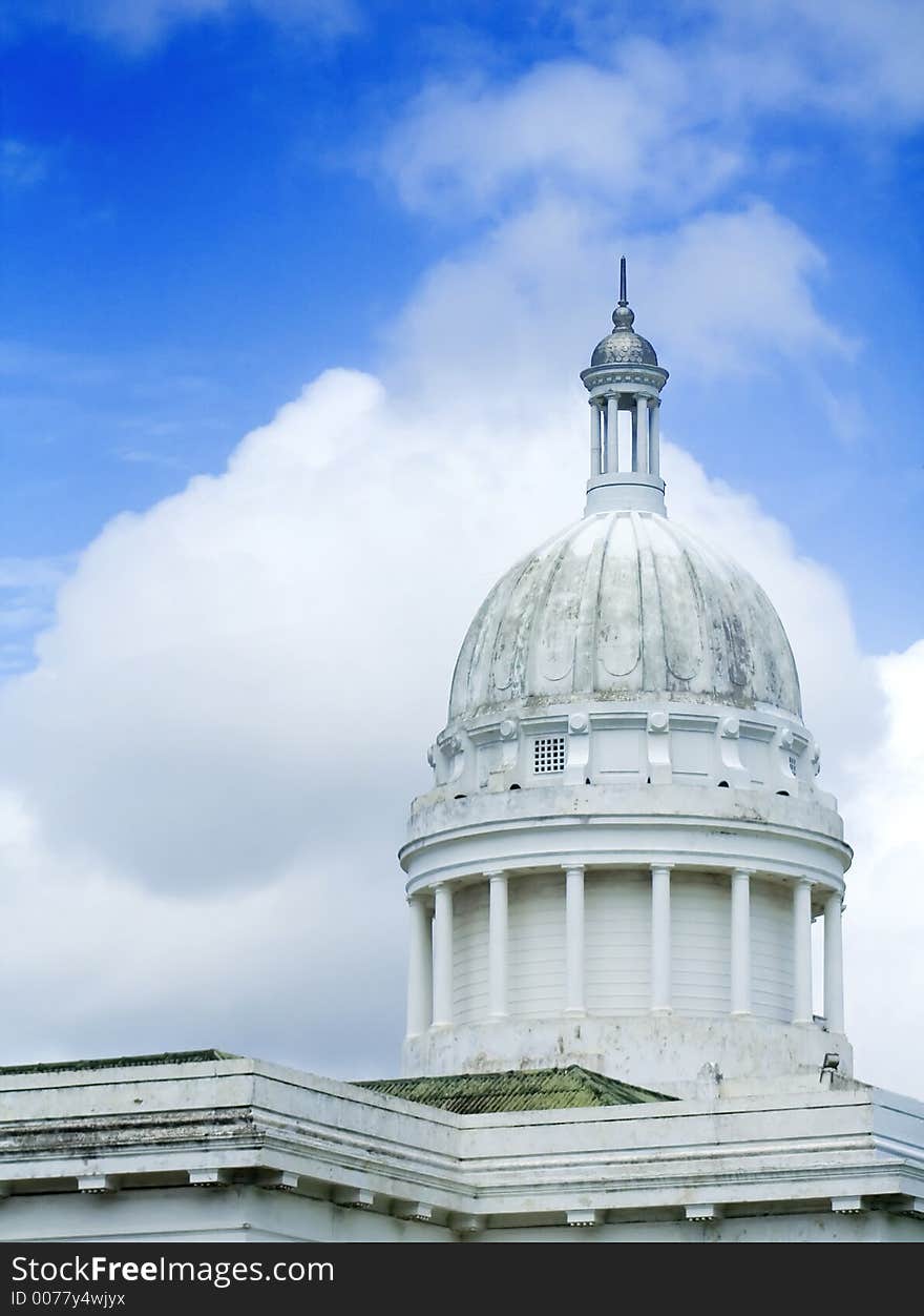 Classic white building with beautiful blue sky and clouds in background