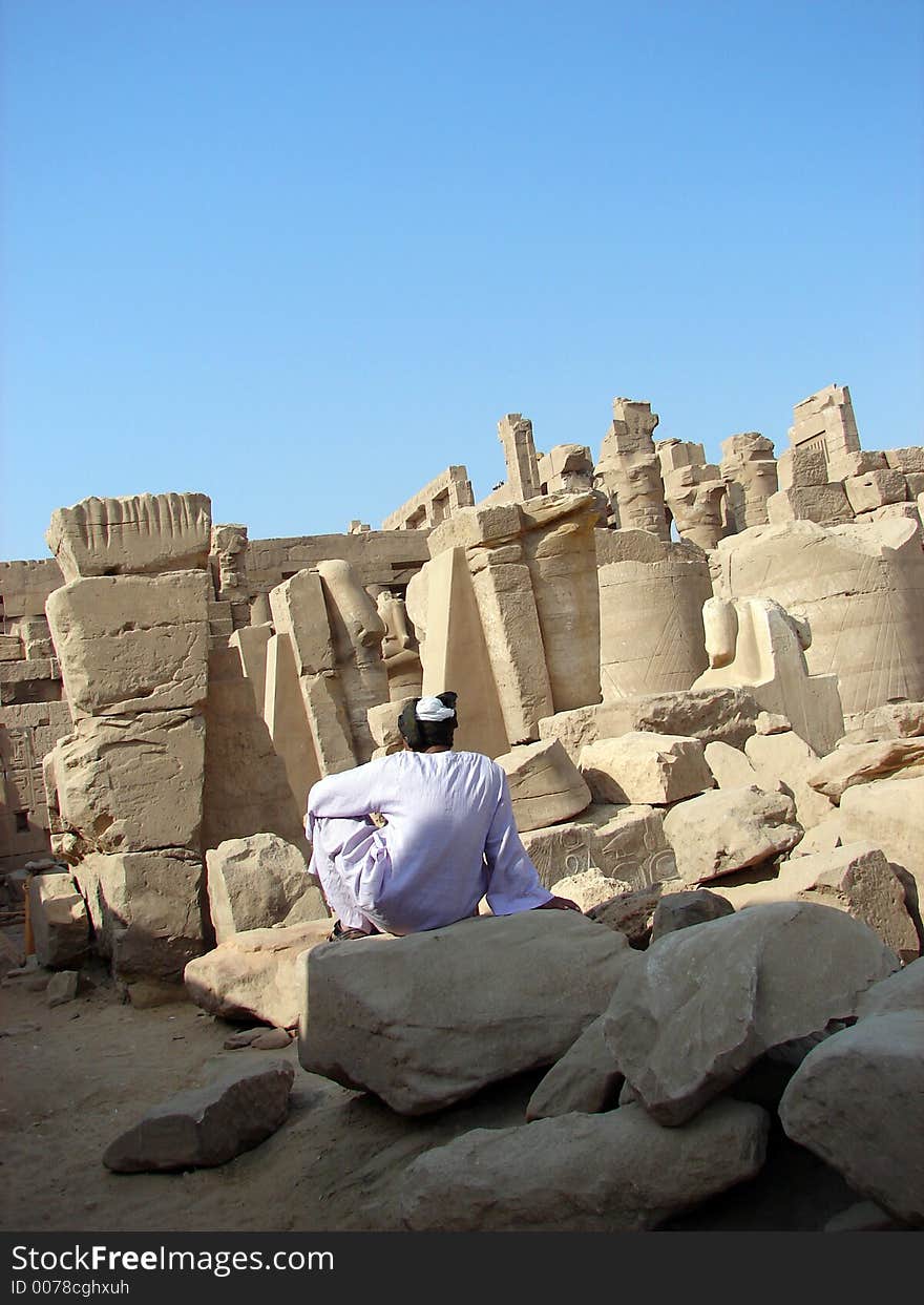 Man sitting on the ruins of Luxor