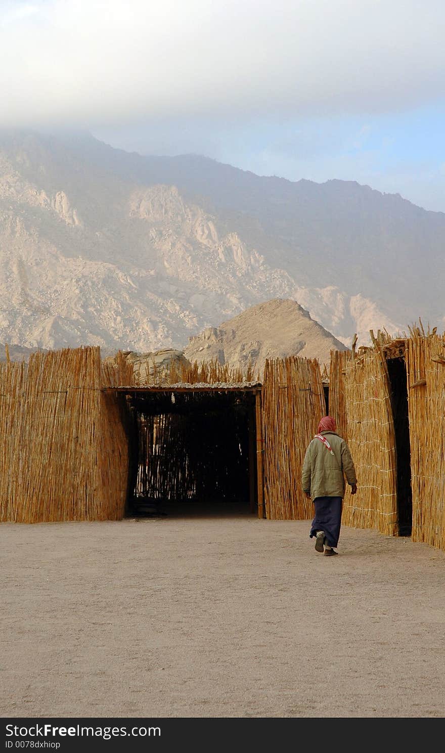 A man walking to his hut. A man walking to his hut