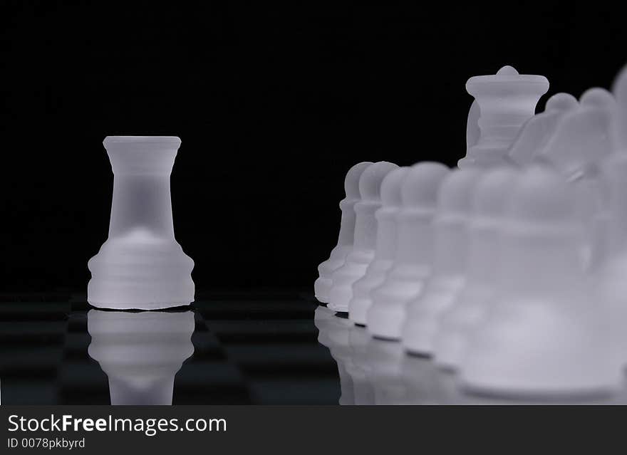 A rook from a glass chess set is out of line with rows of pieces from the same side. A rook from a glass chess set is out of line with rows of pieces from the same side.