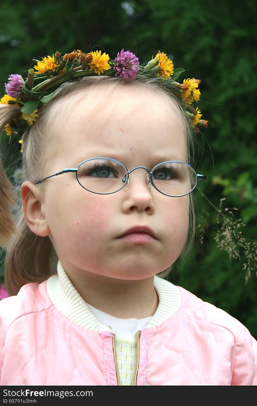 A girl wearing glasses and wreath of flowers outdoor. A girl wearing glasses and wreath of flowers outdoor