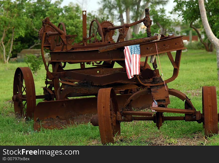 A rusty old tractor sitting in a green field. A rusty old tractor sitting in a green field