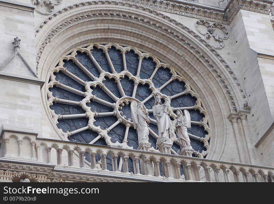 Stained Glass window from the notre dame cathedral in paris with angel statues in fron. Stained Glass window from the notre dame cathedral in paris with angel statues in fron