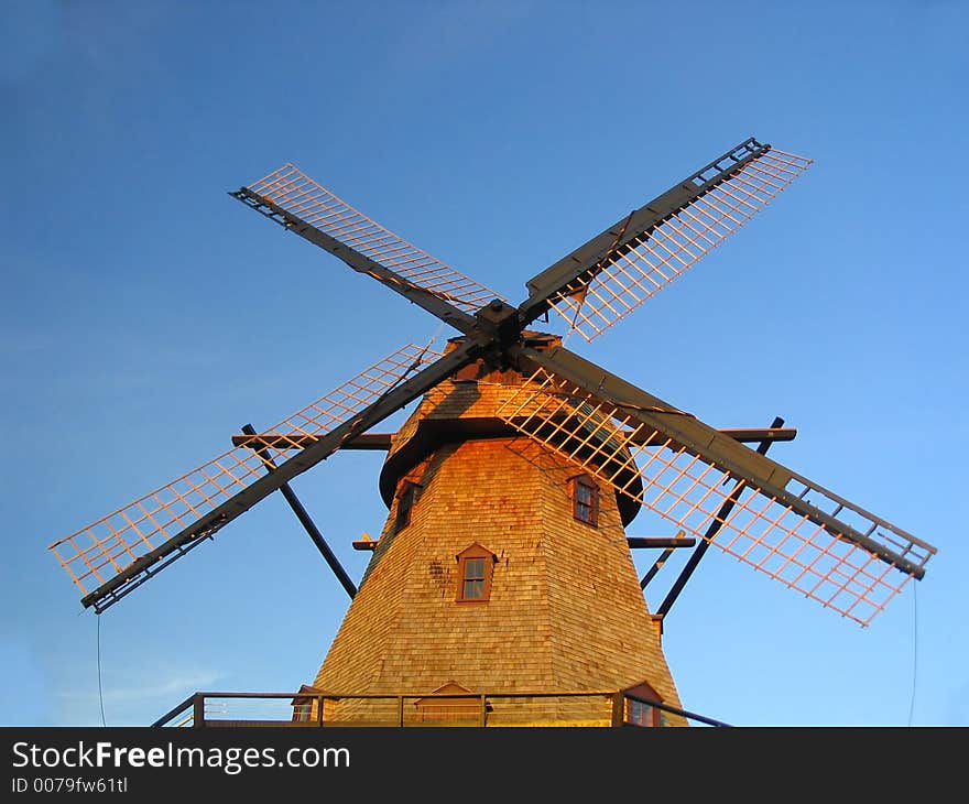 Windmill against blue sky with blades tied down