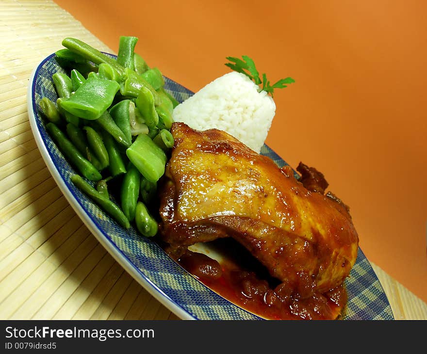 Chicken whit tomato sauce and cooked rice served whit green beans