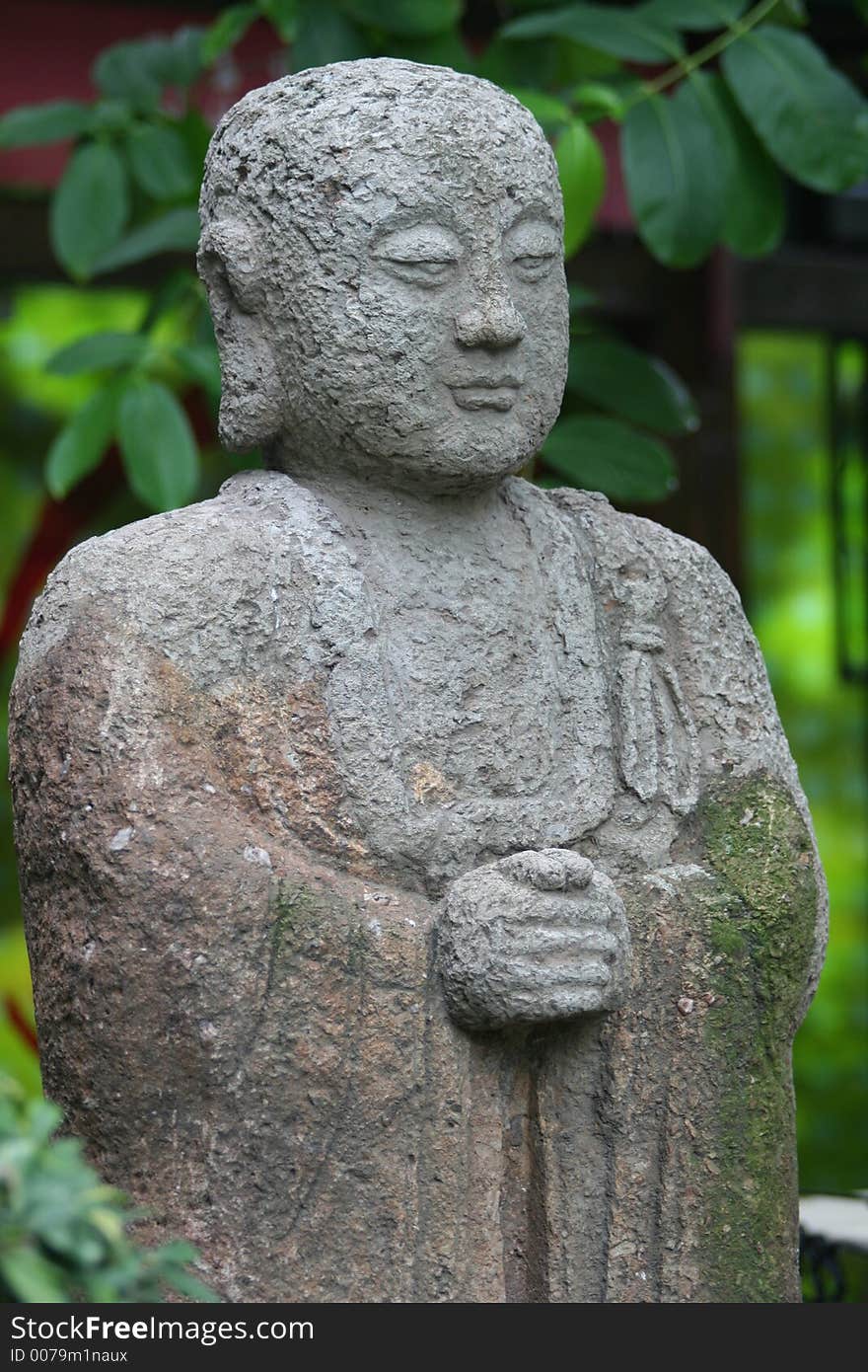 Asian statue on green leaf background