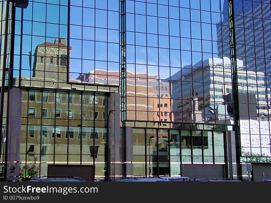 Reflections of downtown buildings in a glass office building. Reflections of downtown buildings in a glass office building