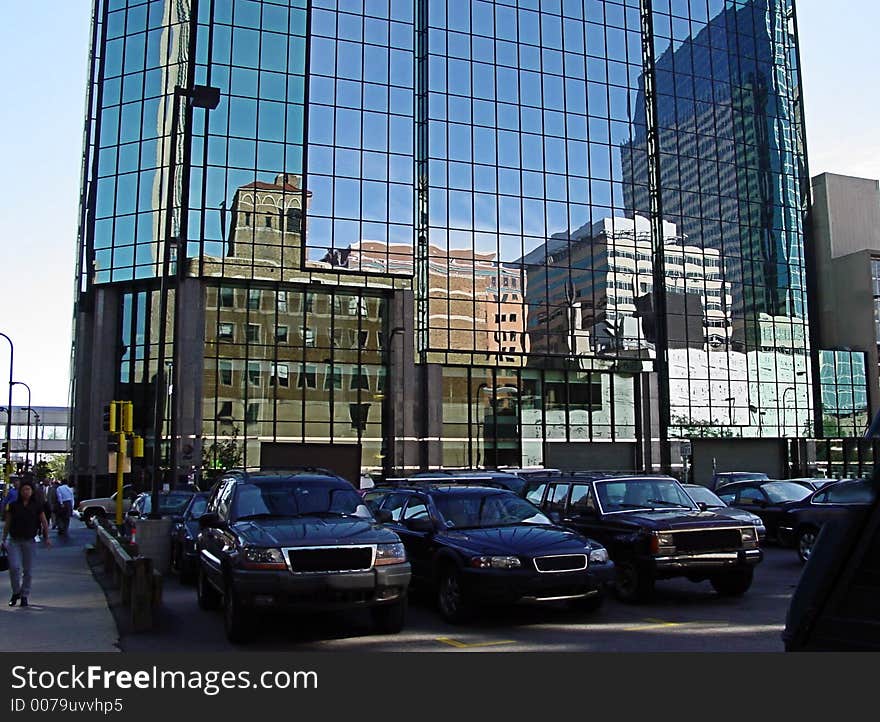 Downtown buildings reflected in glass building at ground level. Downtown buildings reflected in glass building at ground level