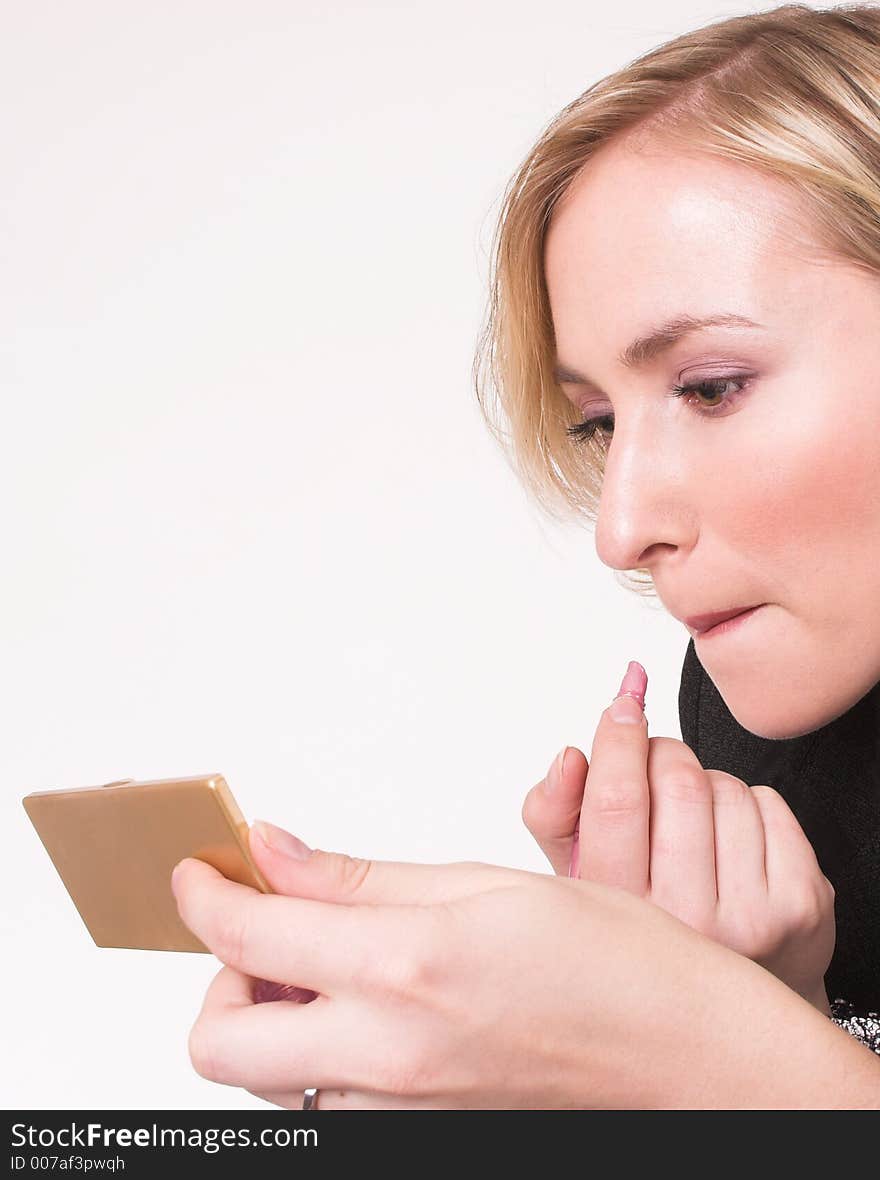 Model putting on makeup while holding mirror