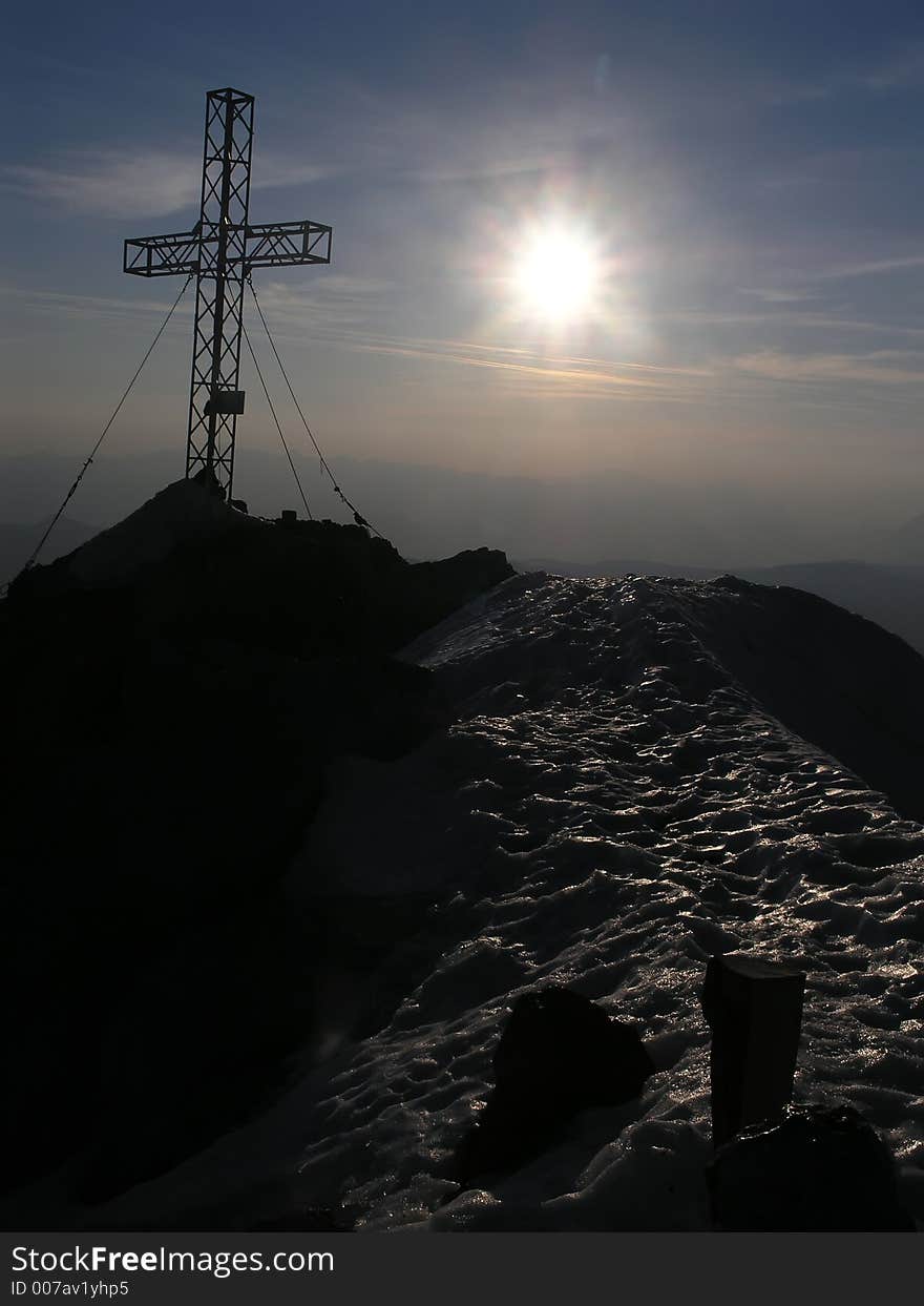 Mountain summit with cross and sun