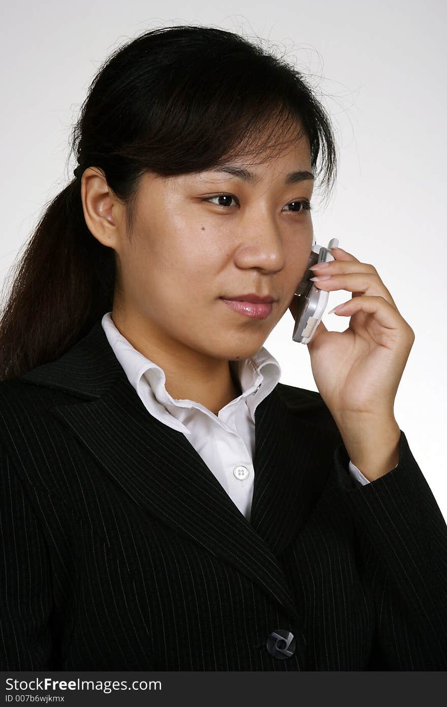 An asian girl talking on the phone'. An asian girl talking on the phone'