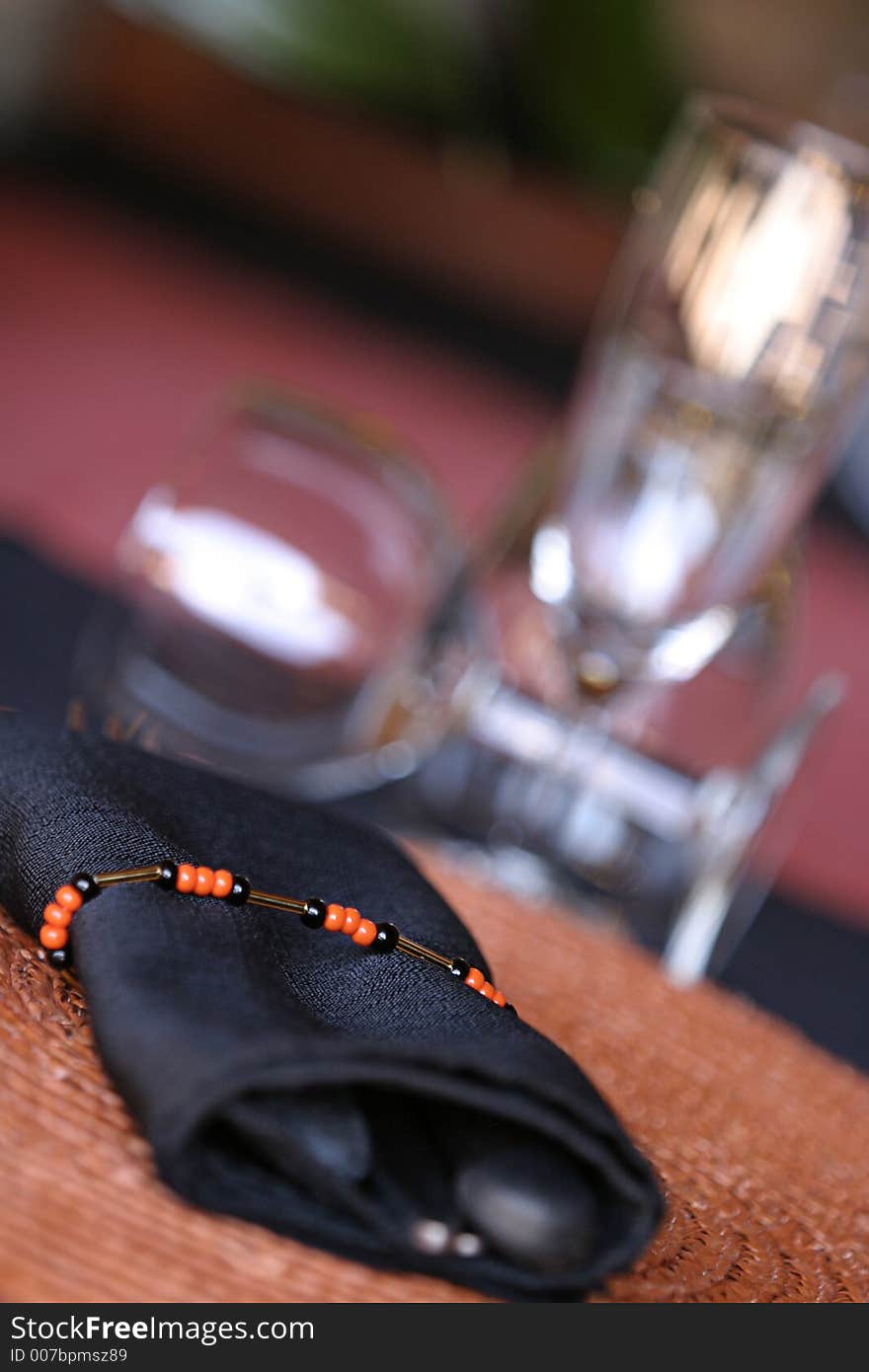 Napkin on table with glasses in the back. Napkin on table with glasses in the back