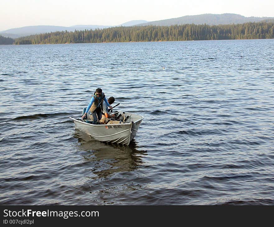 A couple comes back to shore at sunset time after an afternoon of fishing Timothy Lake